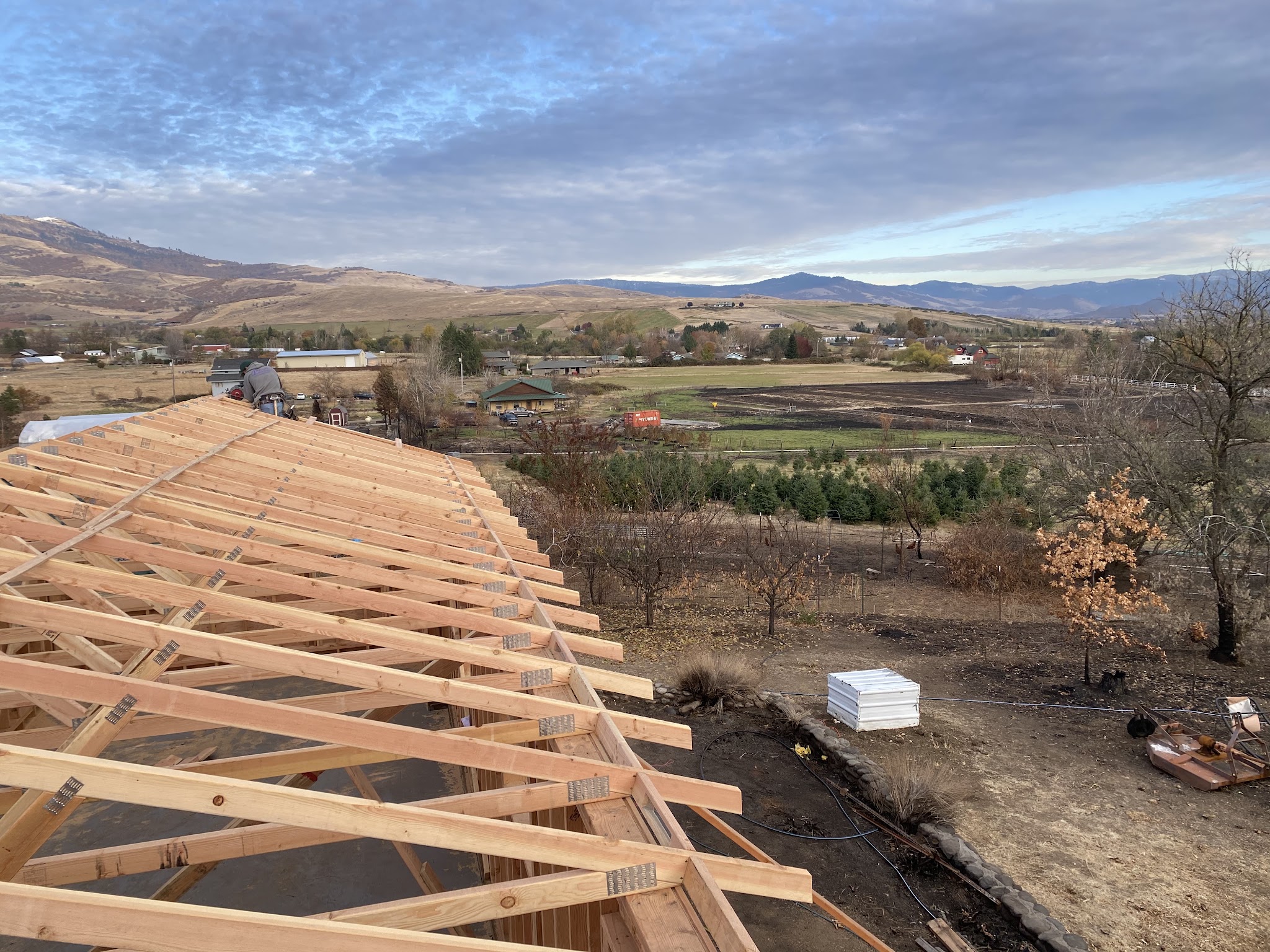 Roof framing viewed from above at sunset, overlooking the Rogue Valley